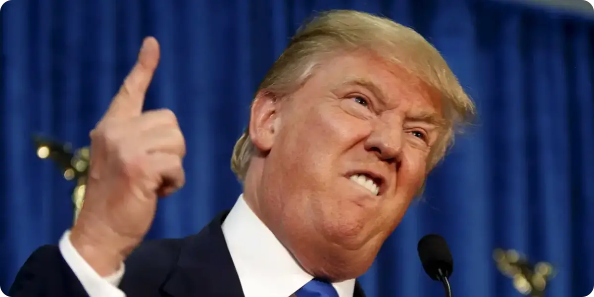 Donald Trump shows an angry face while pointing with his right hand during a public appearance.