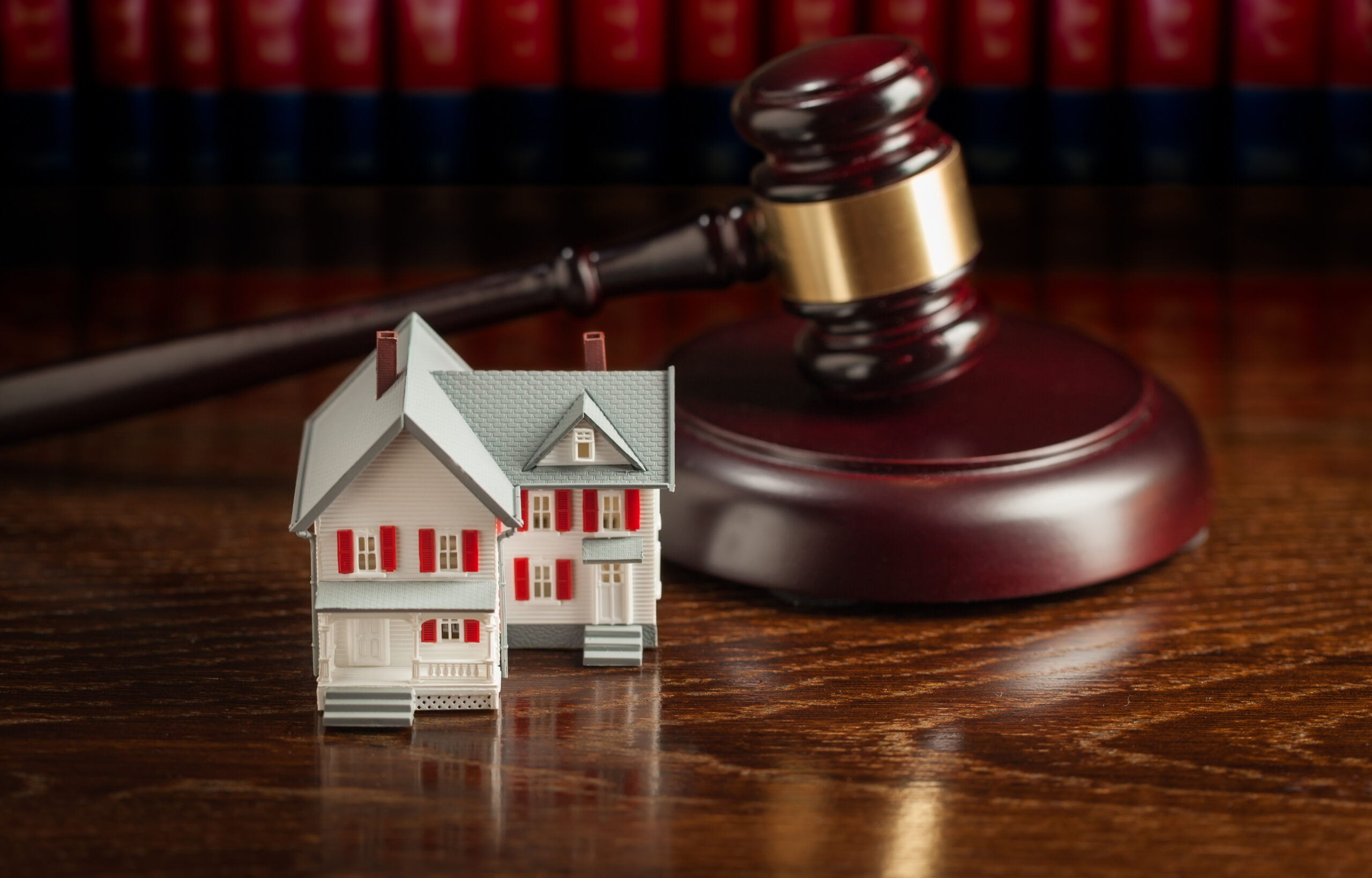 Photo Of a Gavel and Small Model House on Wooden Table