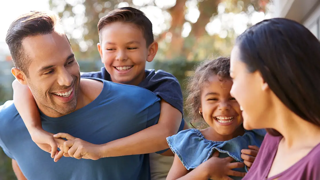 Photo of father, mother, boy, and girl, smiling and looking at each other - Photo by Adobe Stock
