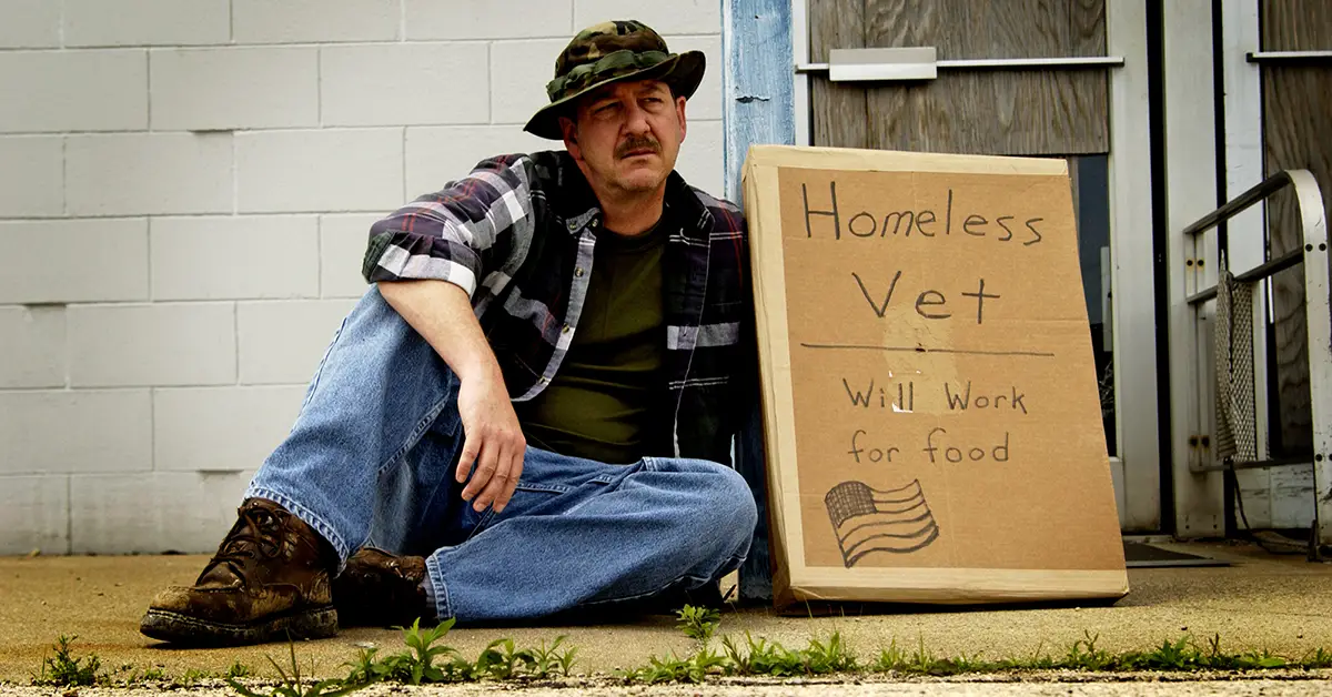 Photo of homeless veteran on street with "Will work for food" sign